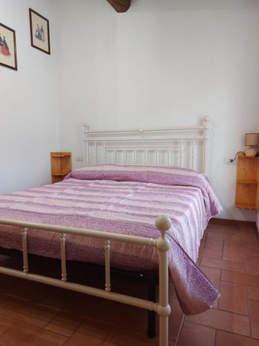 a bedroom with a bed with a purple blanket at Casa Melissa in Greve in Chianti