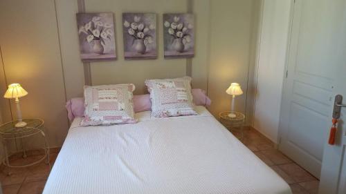 - un lit dans une chambre avec 3 photos sur le mur dans l'établissement Les Lavandins-Gite Vincent, à Saint-Rémy-de-Provence