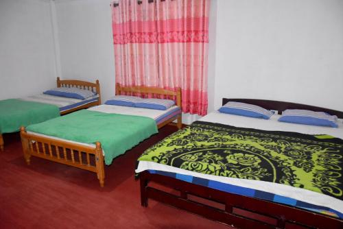 a room with three beds in a room at Carmalin Holiday Bungalow in Nuwara Eliya