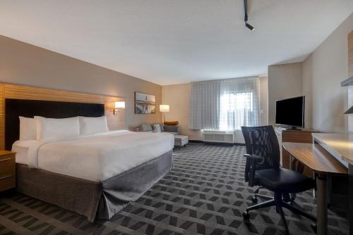 a hotel room with a bed and a desk and a computer at Courtyard St. Louis Brentwood in Richmond Heights