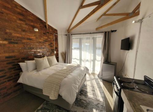 a bedroom with a bed and a brick wall at Trendy apartments _ @ Craftsmanship on main in Johannesburg