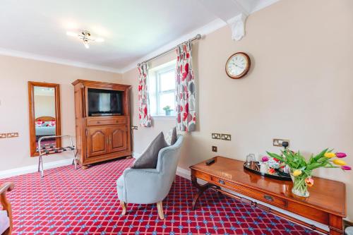 a living room with a desk and a clock on the wall at The Old Vicarage in Bridgnorth