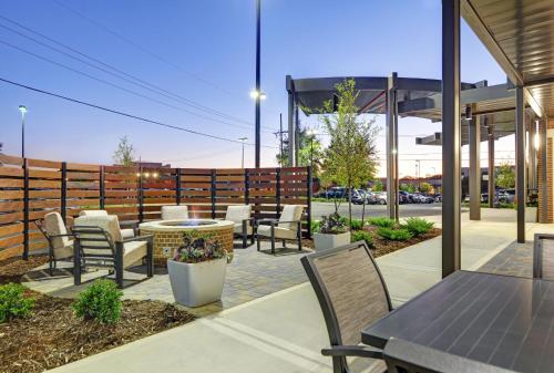 d'une terrasse avec des chaises, des tables et une clôture. dans l'établissement TownePlace Suites by Marriott Jackson Airport/Flowood, à Flowood