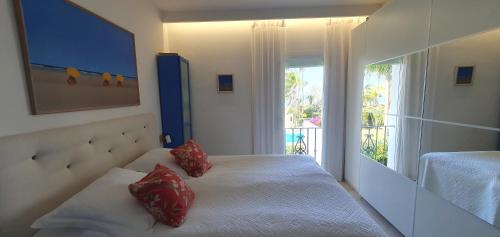Un dormitorio con una cama con almohadas rojas. en Costalita Seaview, en Estepona