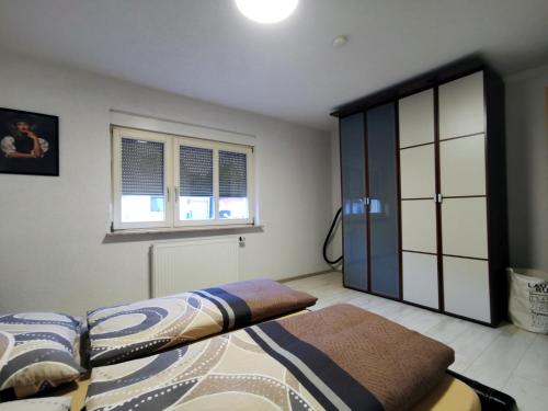 een slaapkamer met een bed en een raam bij 3 Zimmer Ferienwohnung mit eigenem Garten Trossingen in Trossingen