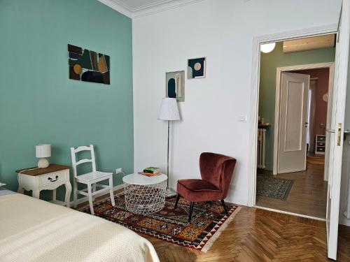 a bedroom with a bed and a chair and a table at Casa Torino Liberty in Turin