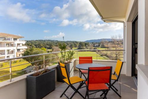 a balcony with a table and chairs and a view at Domaine d'Arca - Gauguin 12 - 2 chambres - étage 2 in Porto-Vecchio