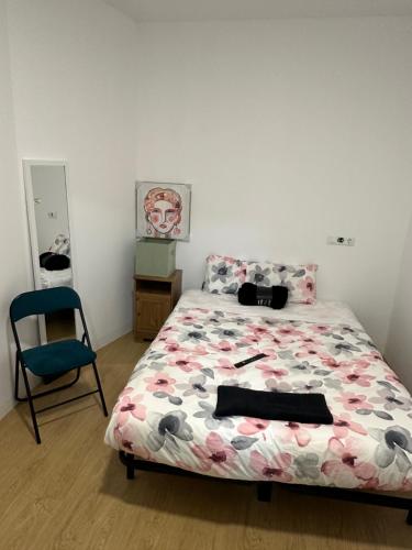 1 dormitorio con 1 cama y 1 silla azul en Loft completo, en Sant Boi del Llobregat