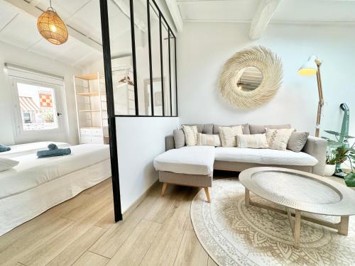 - un salon avec un canapé, un lit et un miroir dans l'établissement Cosy 3 pièces vieil Antibes proche port Vauban, à Antibes