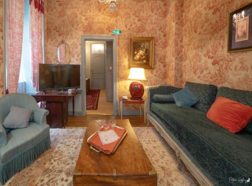 - un salon avec deux canapés et une télévision dans l'établissement la Forge du Roy, à Blois