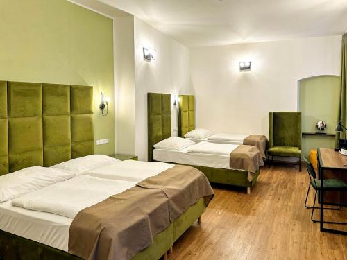 a hotel room with two beds and a desk at Hotel Garden Court in Prague