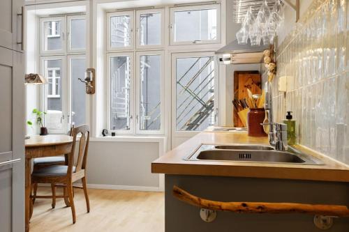een keuken met een wastafel, een tafel en ramen bij New Spacious & Cozy Hideaway with Central Location in Bergen