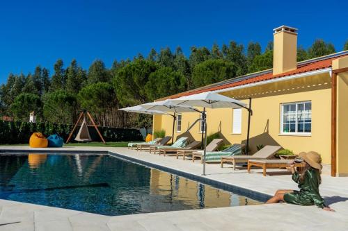 a little girl sitting next to a swimming pool at Quinta Vale Lameiros in Abraã