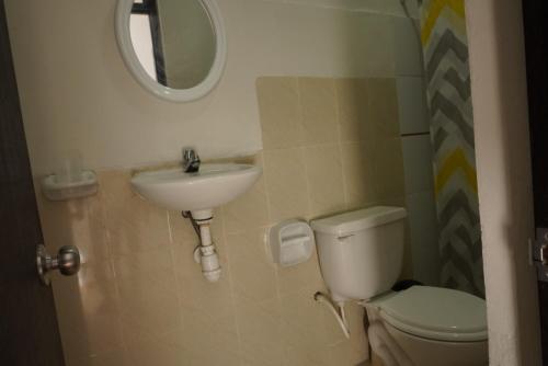 a bathroom with a sink and a toilet and a mirror at Casa habitacion, 4 dormitorios in Tarapoto