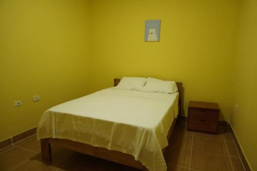 Dormitorio pequeño con cama con manta blanca en Casa habitacion, 4 dormitorios, en Tarapoto