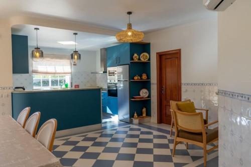 a kitchen with blue cabinets and a checkered floor at Quinta Vale Lameiros 