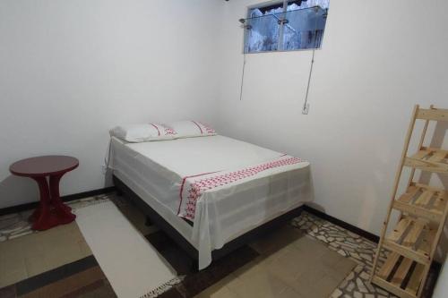 a small bed in a room with a small table at Apartamento em Stella Maris in Salvador