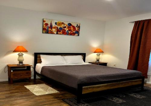 Amazing 3 BD Apartment In Mid West في نيويورك: غرفة نوم بها سرير ومصباحين على الطاولات