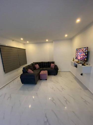 uma sala de estar com um sofá e uma televisão em Apartamento excelente ubicación em Barranquilla