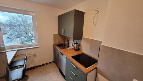 eine Küche mit einer Theke, einem Waschbecken und einem Fenster in der Unterkunft Wohnung in Datteln in Datteln