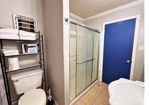 uma casa de banho com um WC e uma cabina de duche em vidro. em Cozy 3br By Houston Ship Channel em Houston