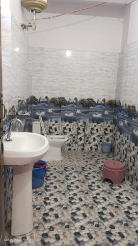 a bathroom with a sink and two toilets in it at Hira Homestay in Bhowāli