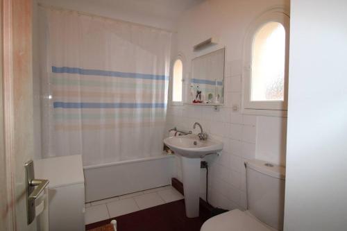 イエールにあるHYEGRASSE Villa pour 6 personnes à 100 mètres de la plage situé sur le Port d'Hyèresの白いバスルーム(洗面台、トイレ付)