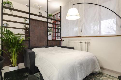 een slaapkamer met een bed en een potplant bij Melissa Apartment in Casalecchio di Reno