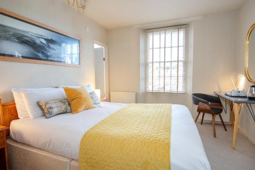 a bedroom with a bed and a table and a desk at Bendene Townhouse - Exeter in Exeter