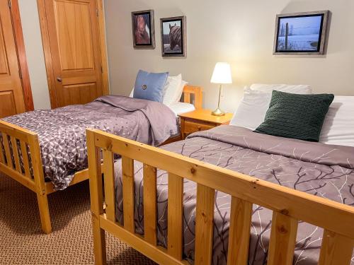 a bedroom with two beds and a wooden crib at Pinnacle Ridge Condos by Fernie Central Reservations in Fernie