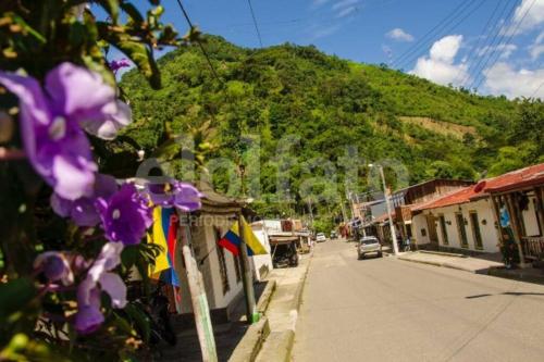 a street in a town with a mountain in the background at Cabaña Canto de las Aguas Cañón del Combeima in Ibagué
