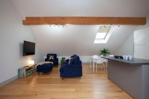 a living room with two blue chairs and a table at higgihaus Cabot Mews #32 Sunday - Friday Central Location in Bristol