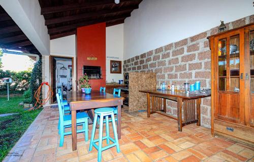 a kitchen with a wooden table and blue chairs at Refúgio Arioli in Porto Alegre