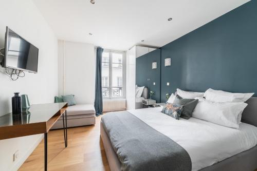 une chambre avec un grand lit avec un mur bleu dans l'établissement Imhost 6 - Charming Appartement Batignolles, à Paris
