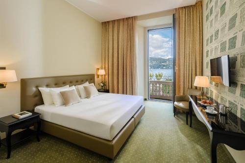 a hotel room with a bed and a large window at Palace Hotel Lake Como in Como