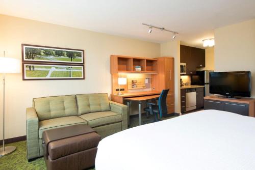 a hotel room with a bed and a couch and a desk at TownePlace Suites by Marriott Lexington South/Hamburg Place in Lexington