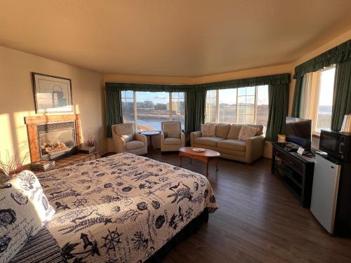 a bedroom with a bed and a living room with a television at Gualala Country Inn in Gualala