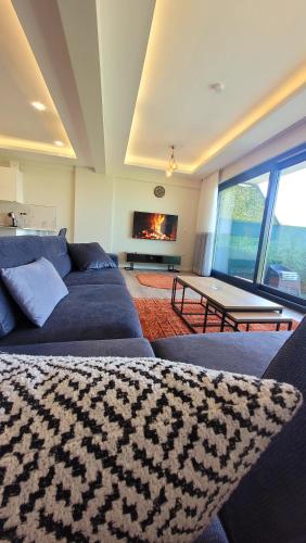 a living room with a blue couch and a fireplace at فلل التن تاج ALTINTAC villalari in Sapanca