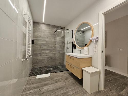 a bathroom with a shower and a sink and a mirror at TuApartamento Loft - Fuente de Navarrería in Pamplona