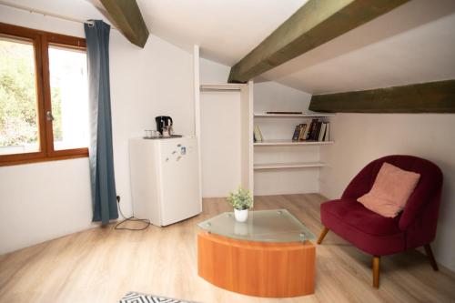 - un salon avec une chaise rouge et une table en verre dans l'établissement Private ROOM, à Montpellier