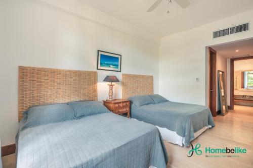 duas camas num quarto de hotel com lençóis azuis em Wonderful 1-BR apartment at Casa de Campo em El Infiernito