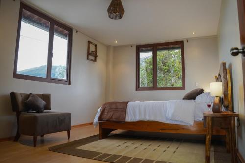 1 dormitorio con 1 cama y 2 ventanas en Casa vacacional en Chambo, en Chambo