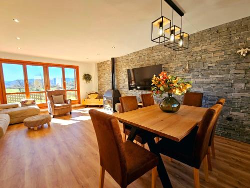 sala de estar con mesa de comedor y pared de piedra en El Rincón del Pirineo, en Senegüé