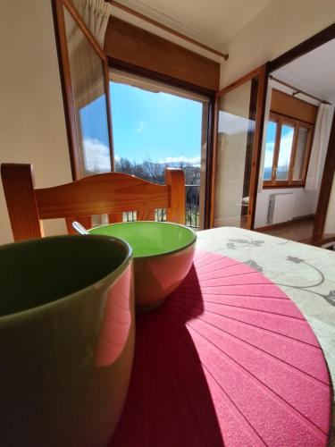 une table avec deux bols verts sur un tapis rose dans l'établissement apartament Eliette 3, à Bagá