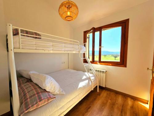 1 dormitorio con litera y ventana en El Rincón del Pirineo, en Senegüé