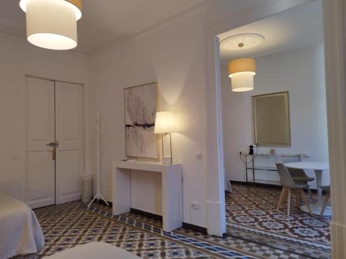 Habitación con escritorio y mesa con lámpara. en Sunny rooms bcn, en Barcelona