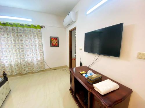 uma sala de estar com uma televisão de ecrã plano na parede em Cozy private Ac Attached bath Room- Gulshan 1 em Daca