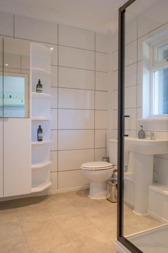 a white bathroom with a toilet and a sink at Stone's Throw Away from the English Channel! -Family and Dog Friendly in Wootton
