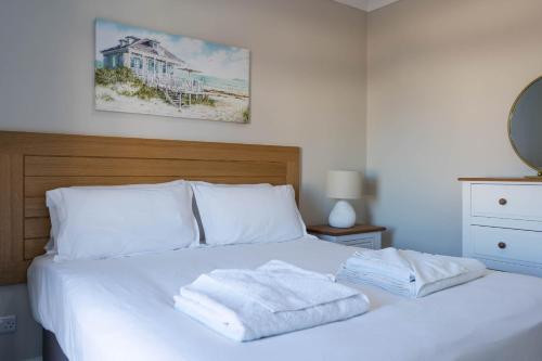 a bedroom with a white bed with two towels on it at Stone's Throw Away from the English Channel! -Family and Dog Friendly in Wootton