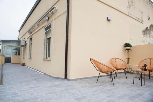 a patio with two chairs and a table and a building at Casa Boschi in centro città in Pescara